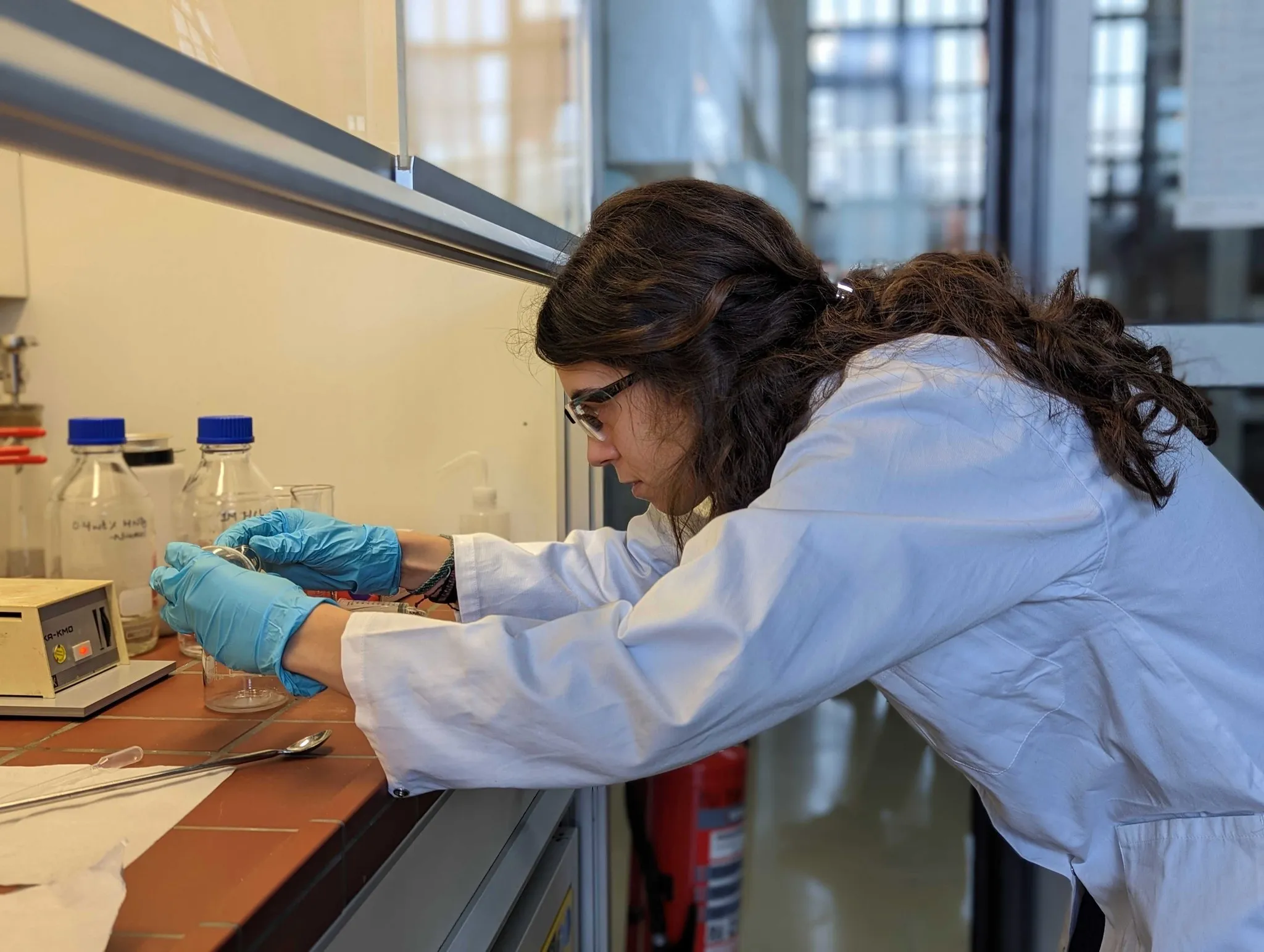 A scientist running capture-material experiments at a fume hood